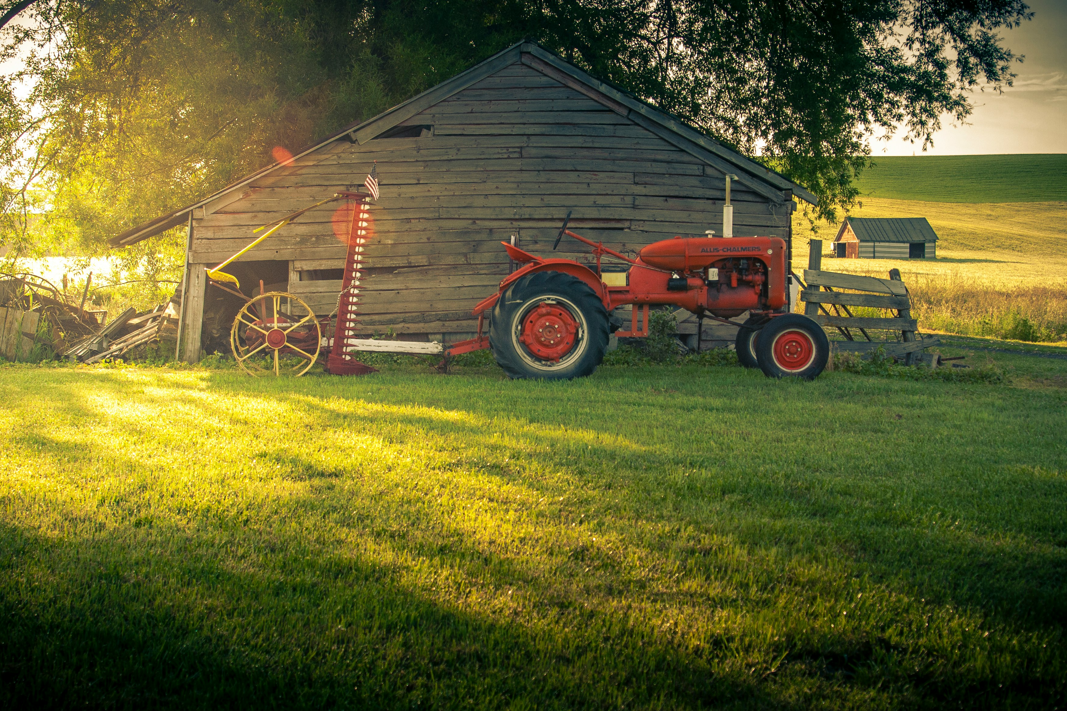 red tractor on green grass field during daytime